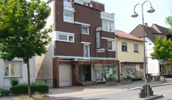 Das Haus der Geschäftsstelle in Ludwigshafen-Gartenstadt, Maudacher Straße 241, mit Backsteinfassade und Ladenfenstern